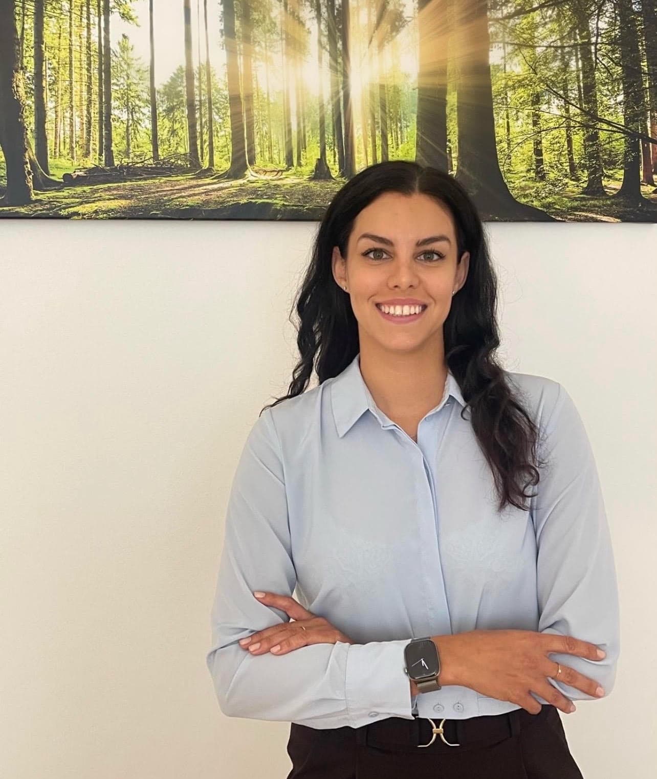 Mag. Irina Weidner vor einem Waldbild in ihrer Praxis